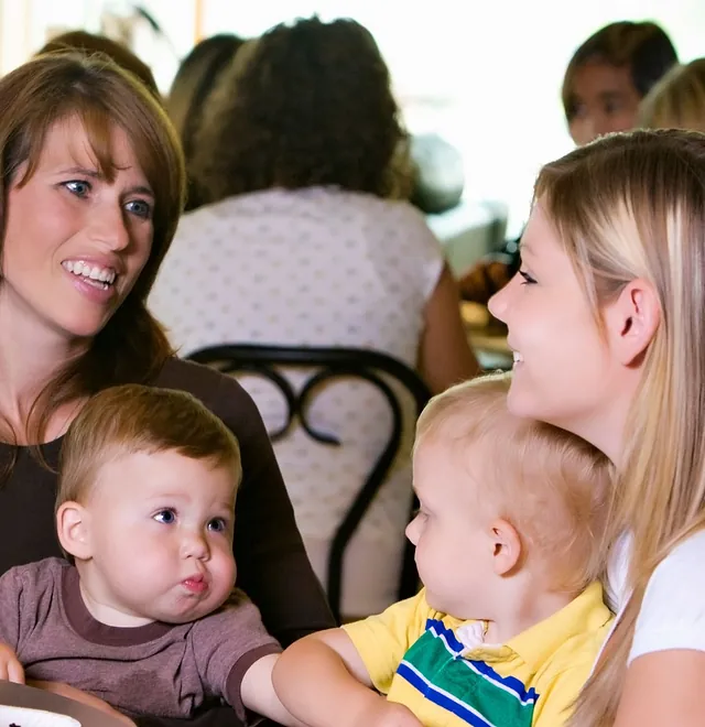 Glückliche Familie genießt Frühstück an einem Tisch mit Gebäck.