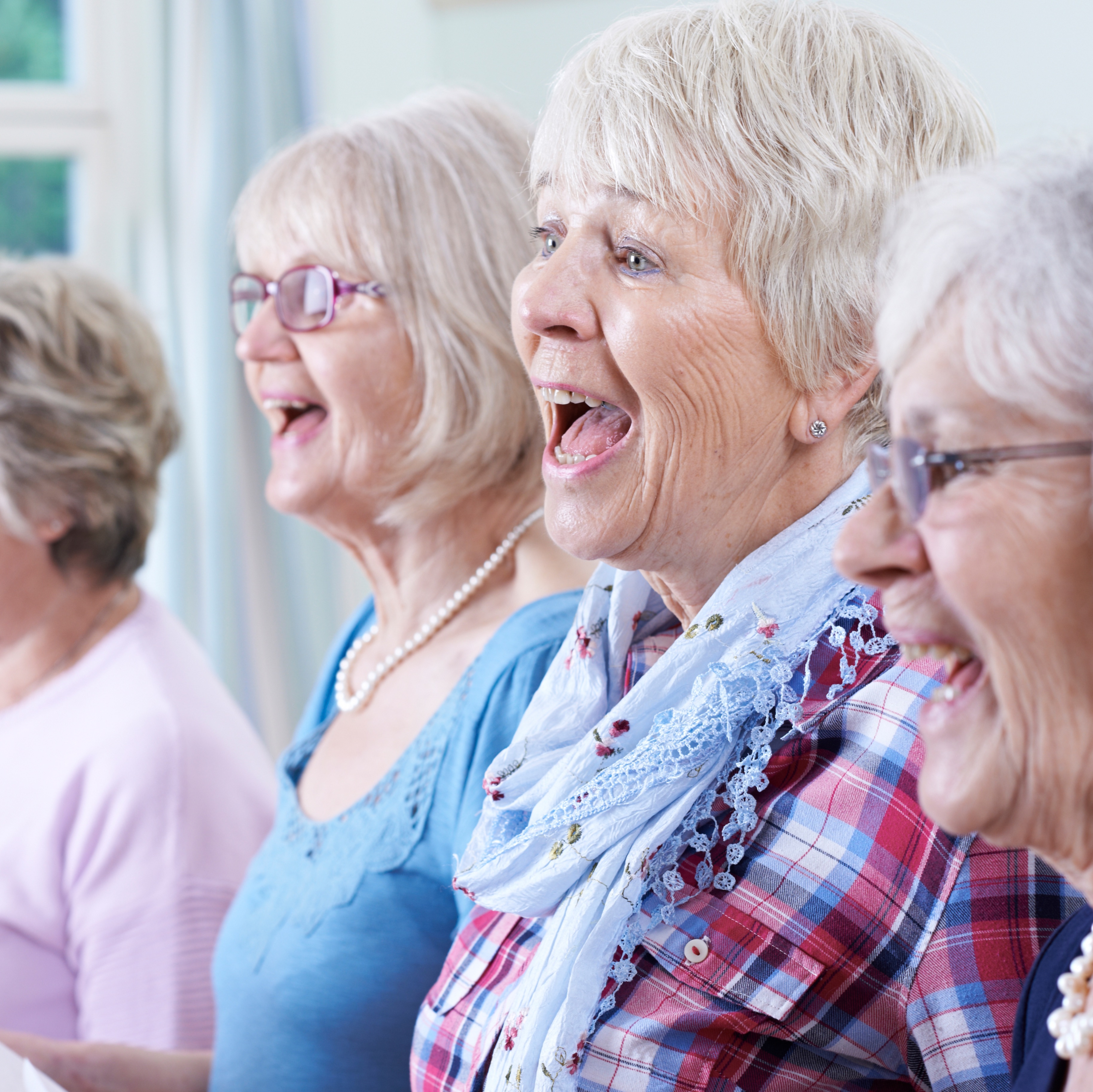 Gruppe älterer Frauen singt freudig zusammen, Nahaufnahme.