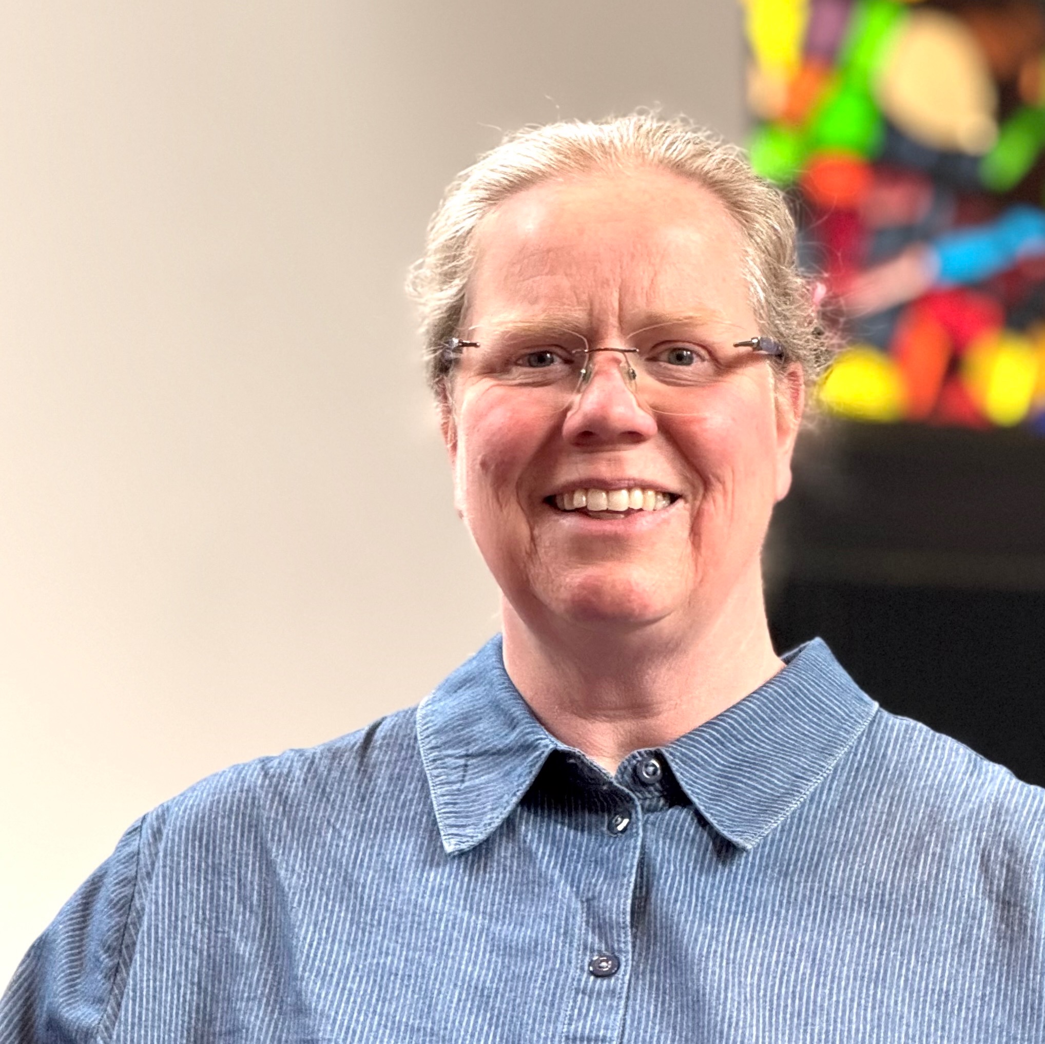 Lächelnde Frau mit kurzen Haaren und Brille Porträt.